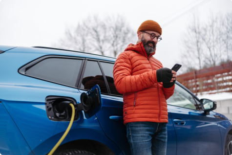 Vyras krauna elektromobilį žiemą