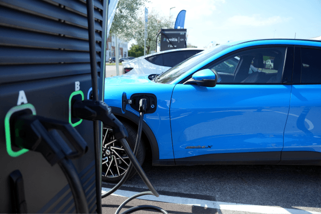 Kraunamas mėlynas elektromobilis