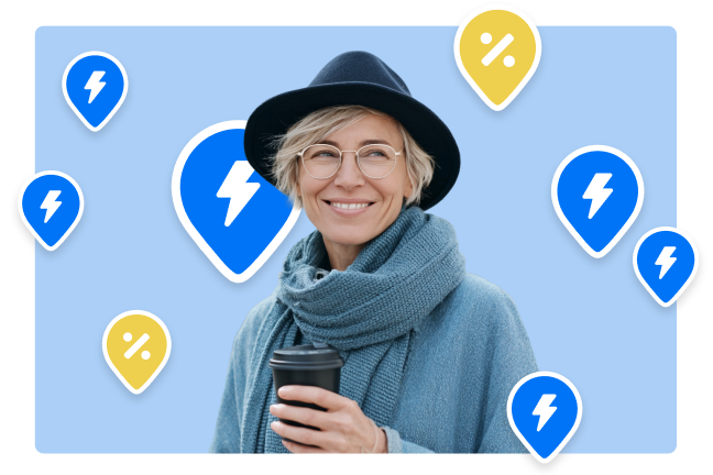 Moteris su kava rankoje šypsosi, o aplink ją fone Ignitis ON įkrovimų stotelių PIN