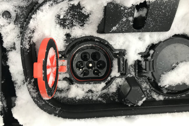 Apsnigta elektromobilio įkrovimo jungtis.