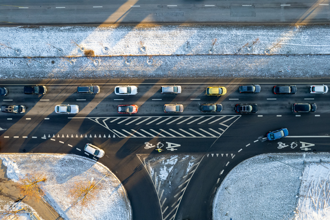 Automobilių eismas gatvėje žiemą.