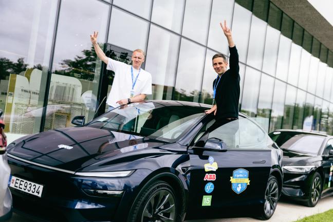Du vyrai džiaugiasi šalia savo elektromobilio