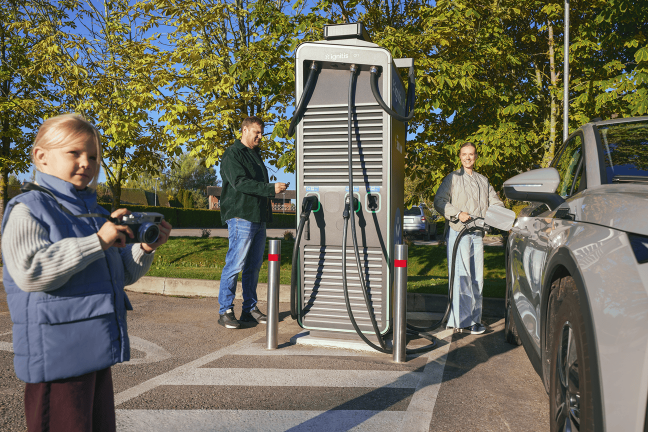 Laiminga šeima įsikrauna elektromobilį Ignitis ON greito įkrovimo stotelėje.